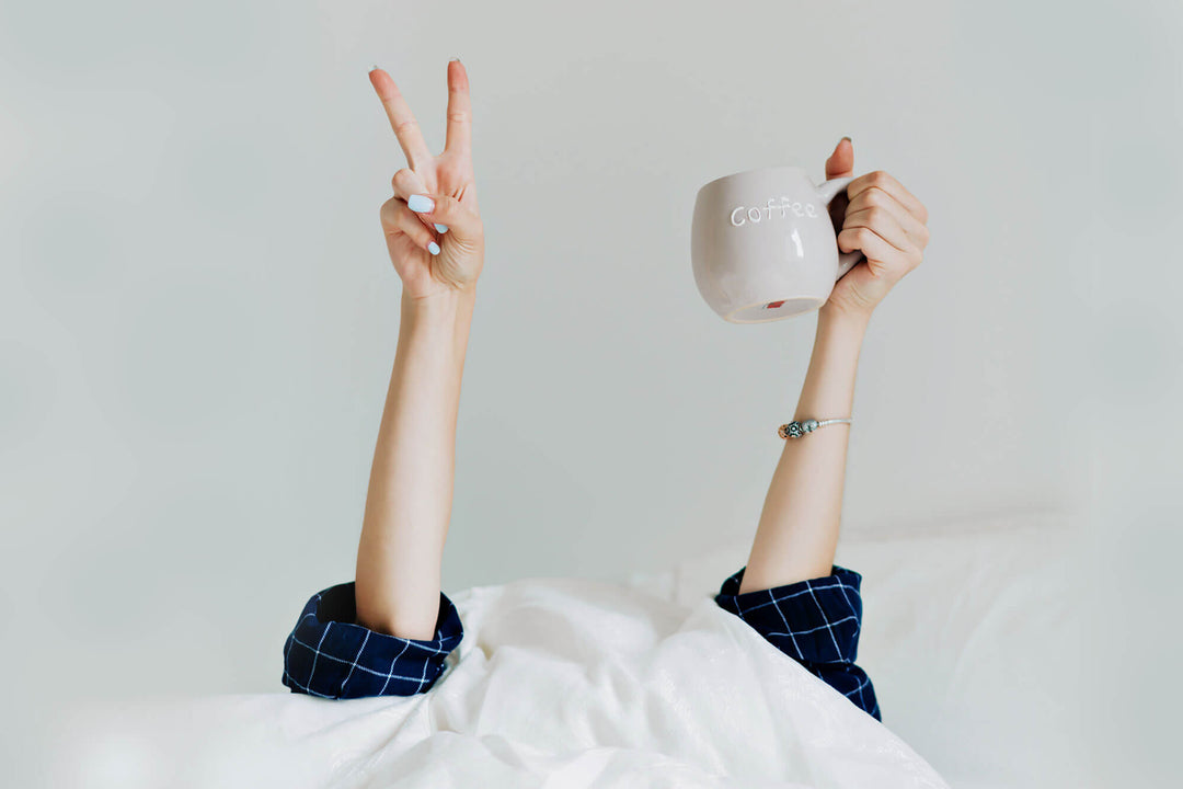 girl in bed with a cup of coffee