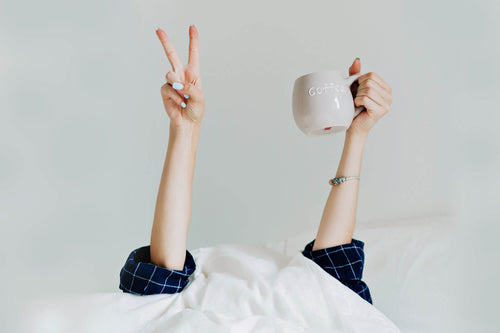 girl in bed with a cup of coffee